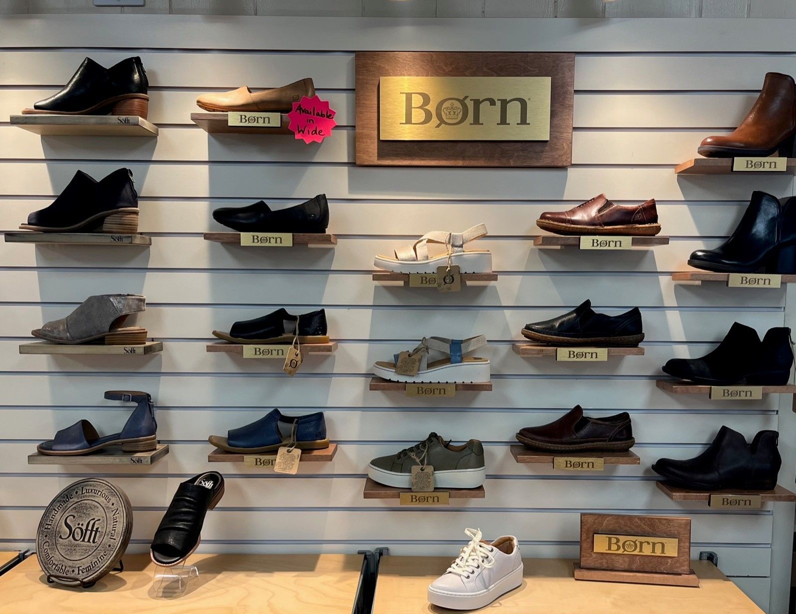 A display of shoes in a store with a sign that says born