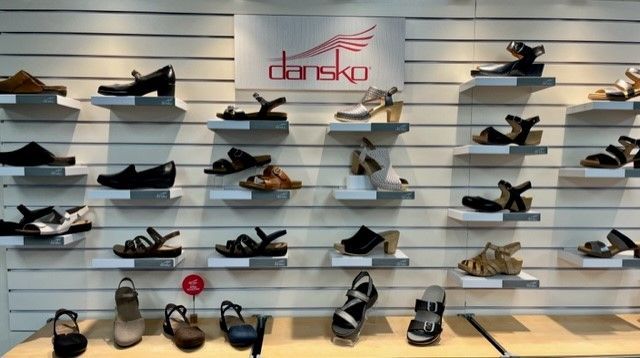 A display of shoes in a store with a sign that says dansko