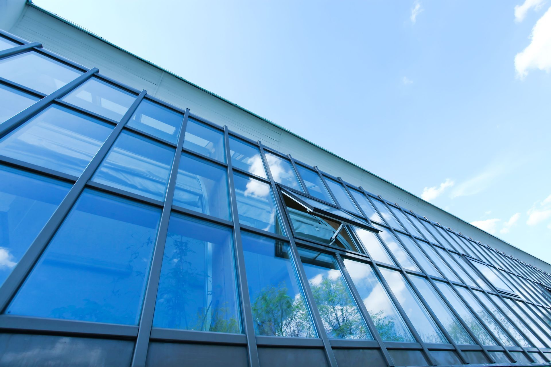 Modern building with reflective blue windows against a clear sky.