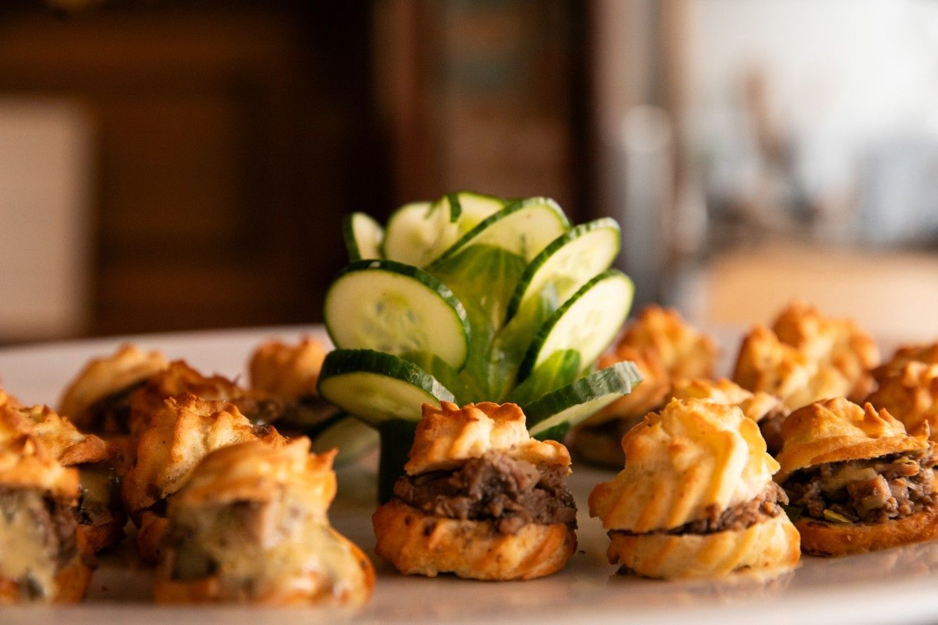 A close up of a plate of food with a cucumber on top.