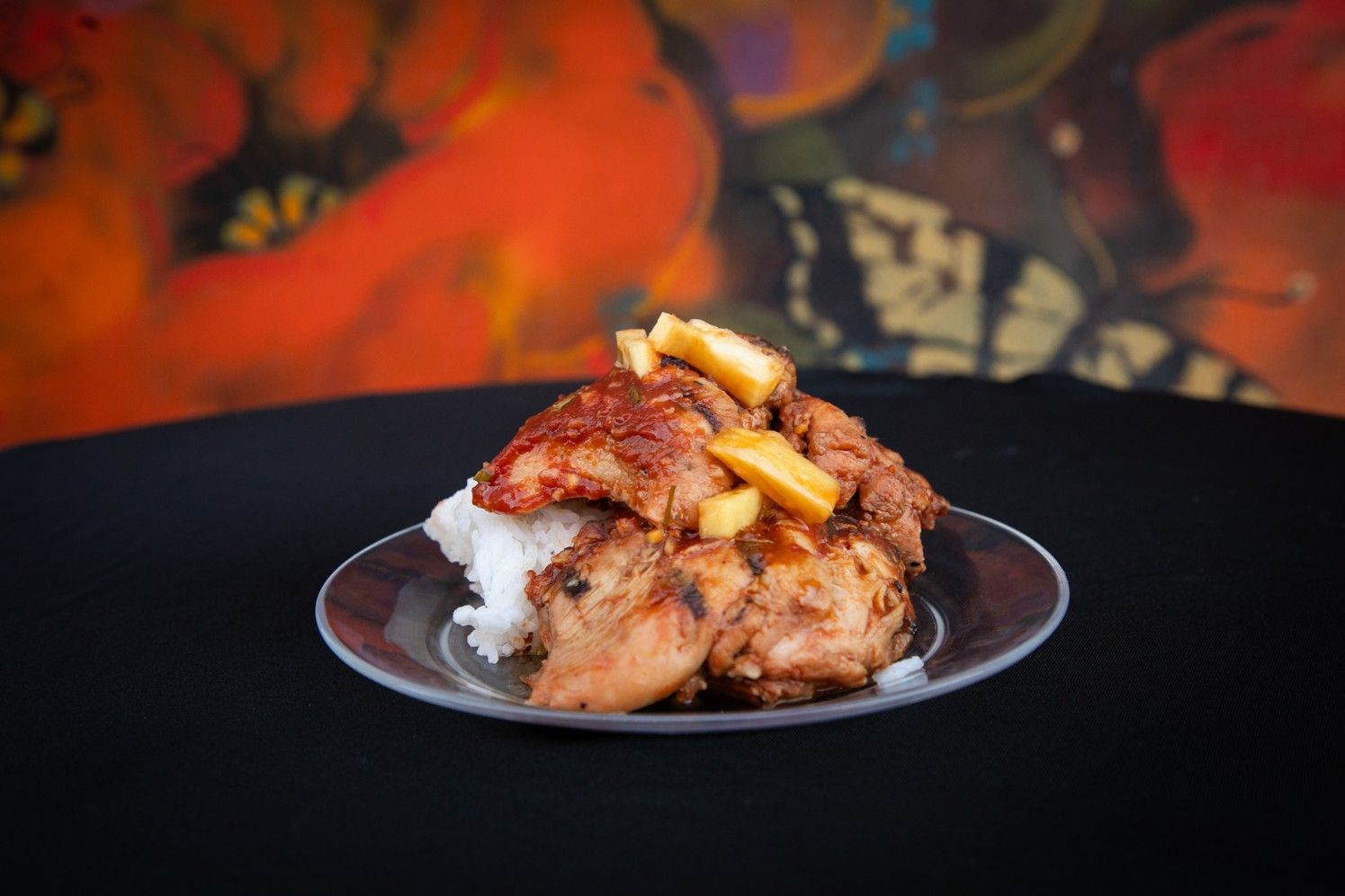 A plate of food with rice and chicken on a table.