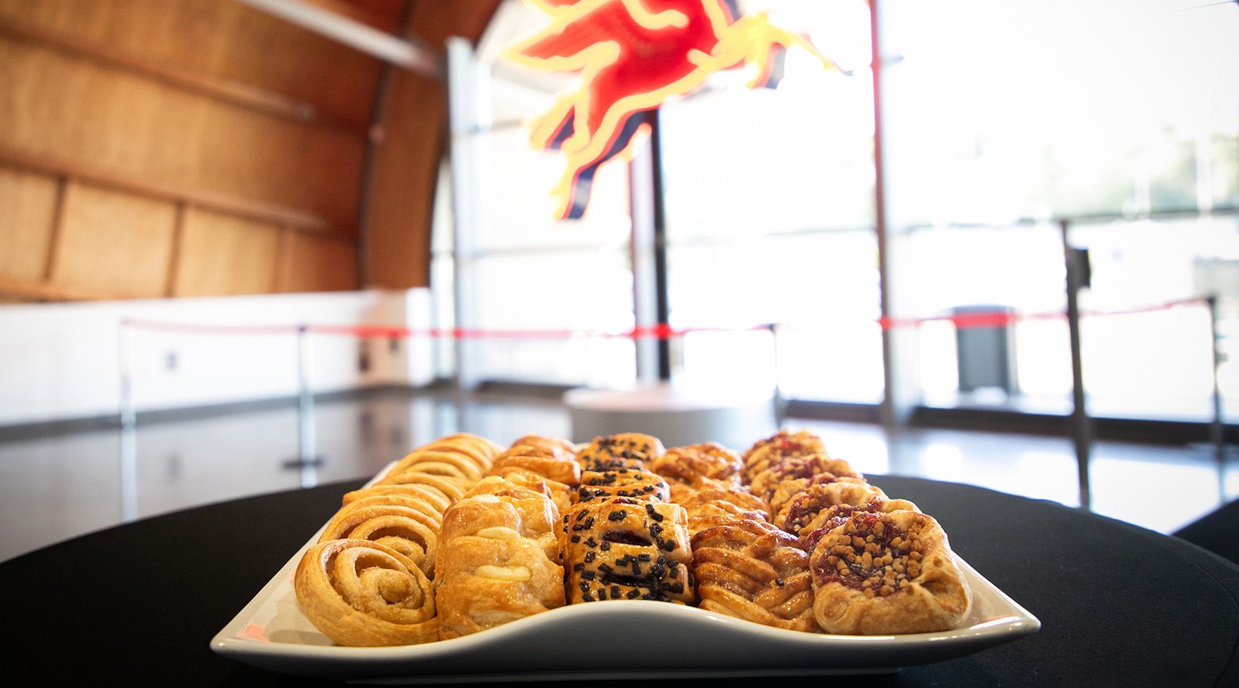 A plate of pastries is sitting on a table in front of a window.