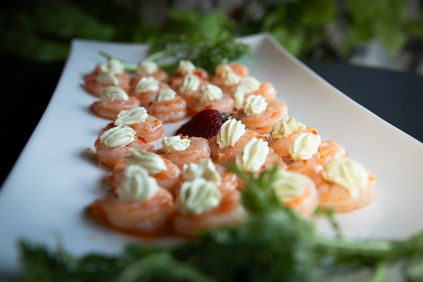 A white plate topped with shrimp and whipped cream.