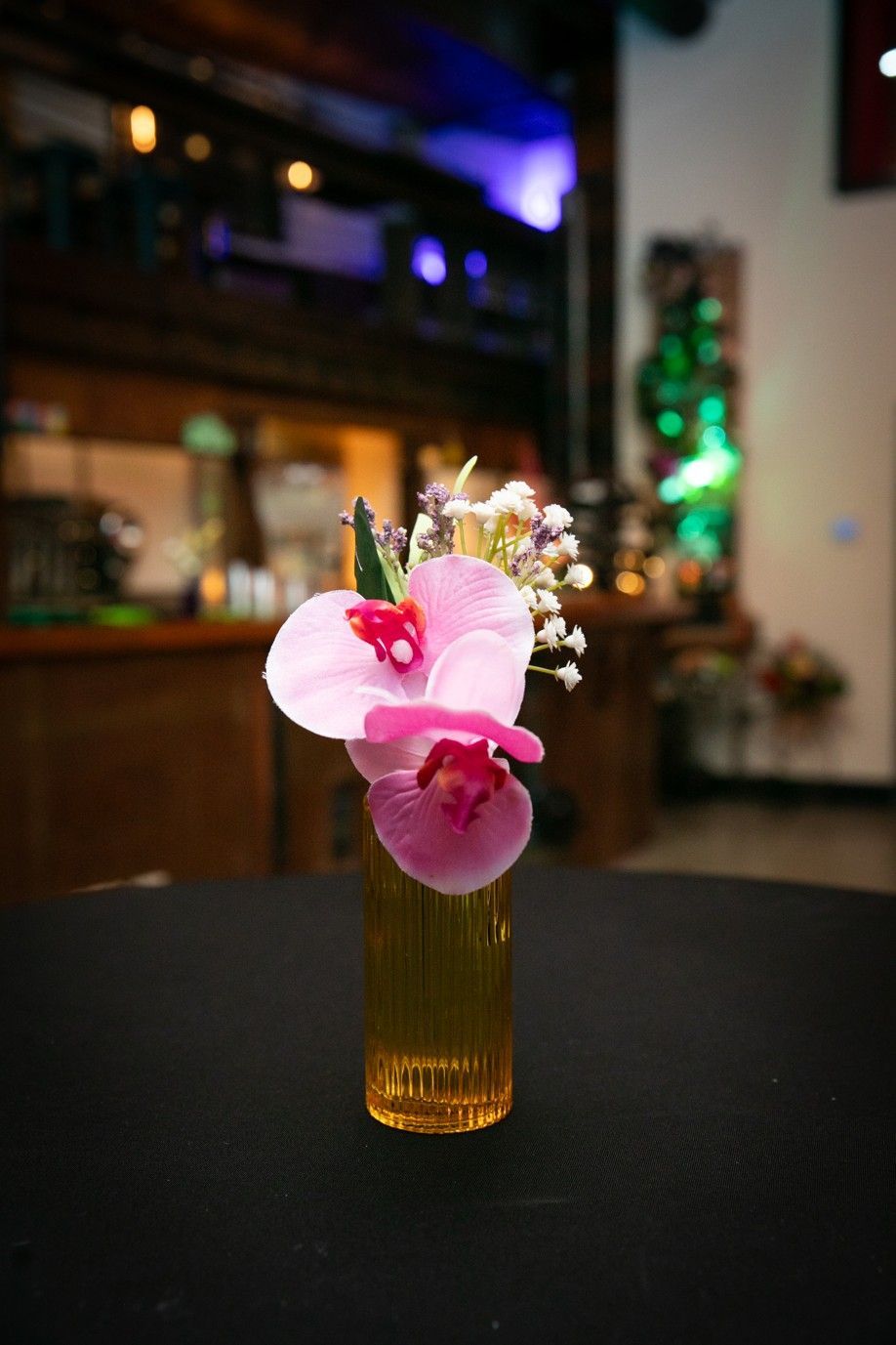 A small vase filled with pink flowers is on a table.