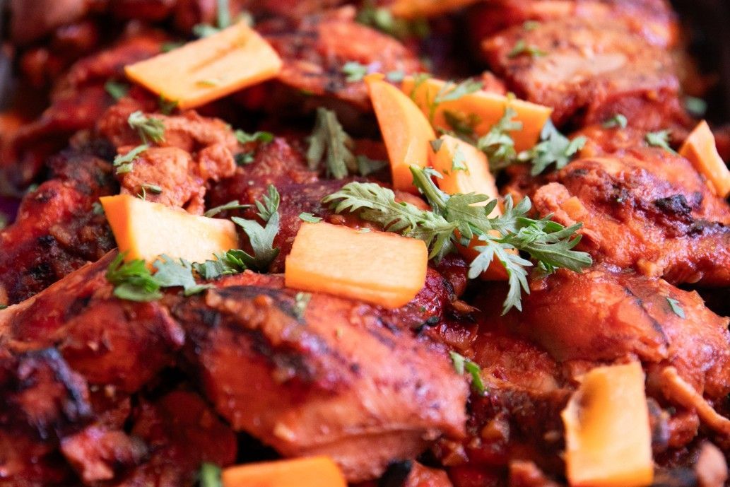A close up of a plate of food with chicken and carrots.