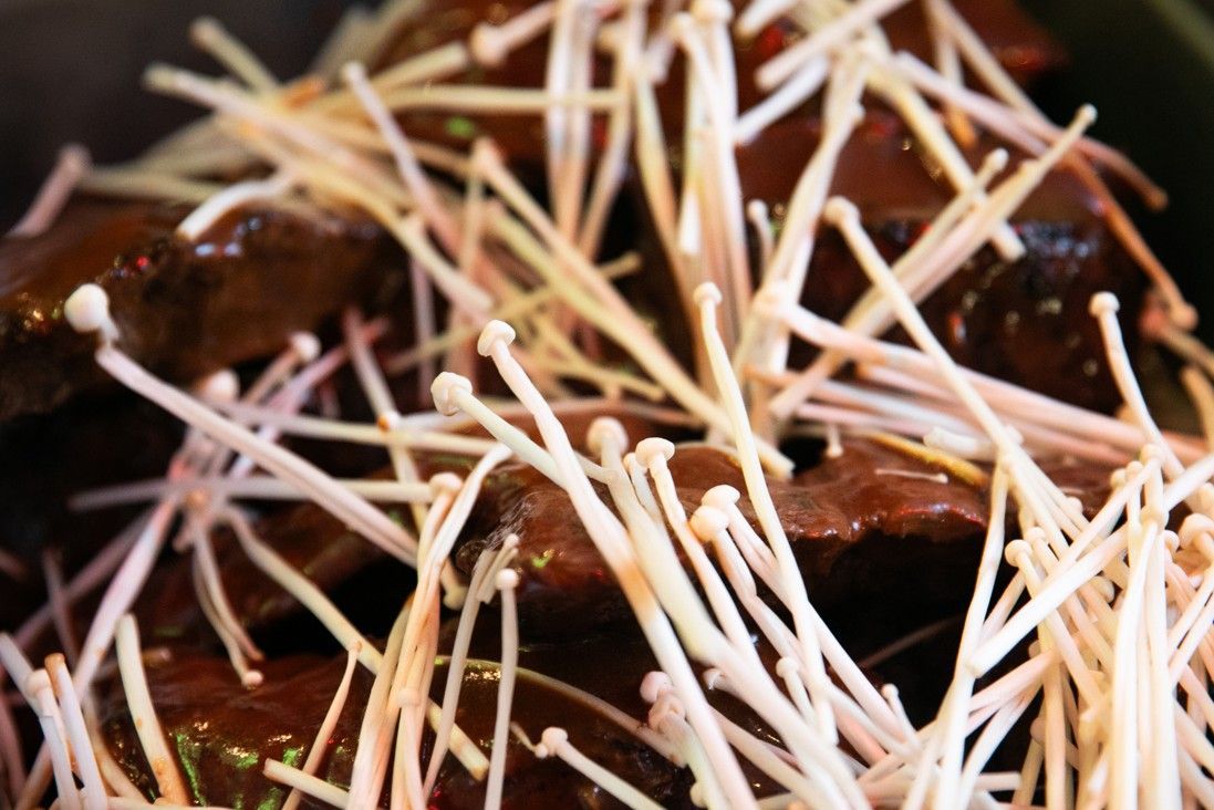 A close up of a plate of food with noodles and mushrooms.