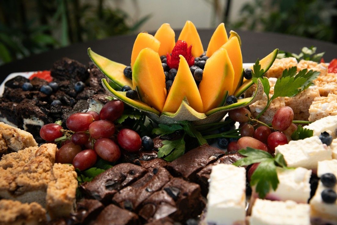 A tray of desserts with a flower made out of fruit on top.