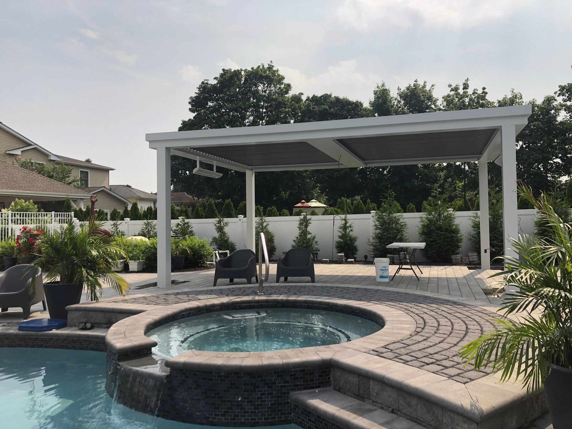 Backyard pool with a covered patio, circular spa, and landscaped seating area