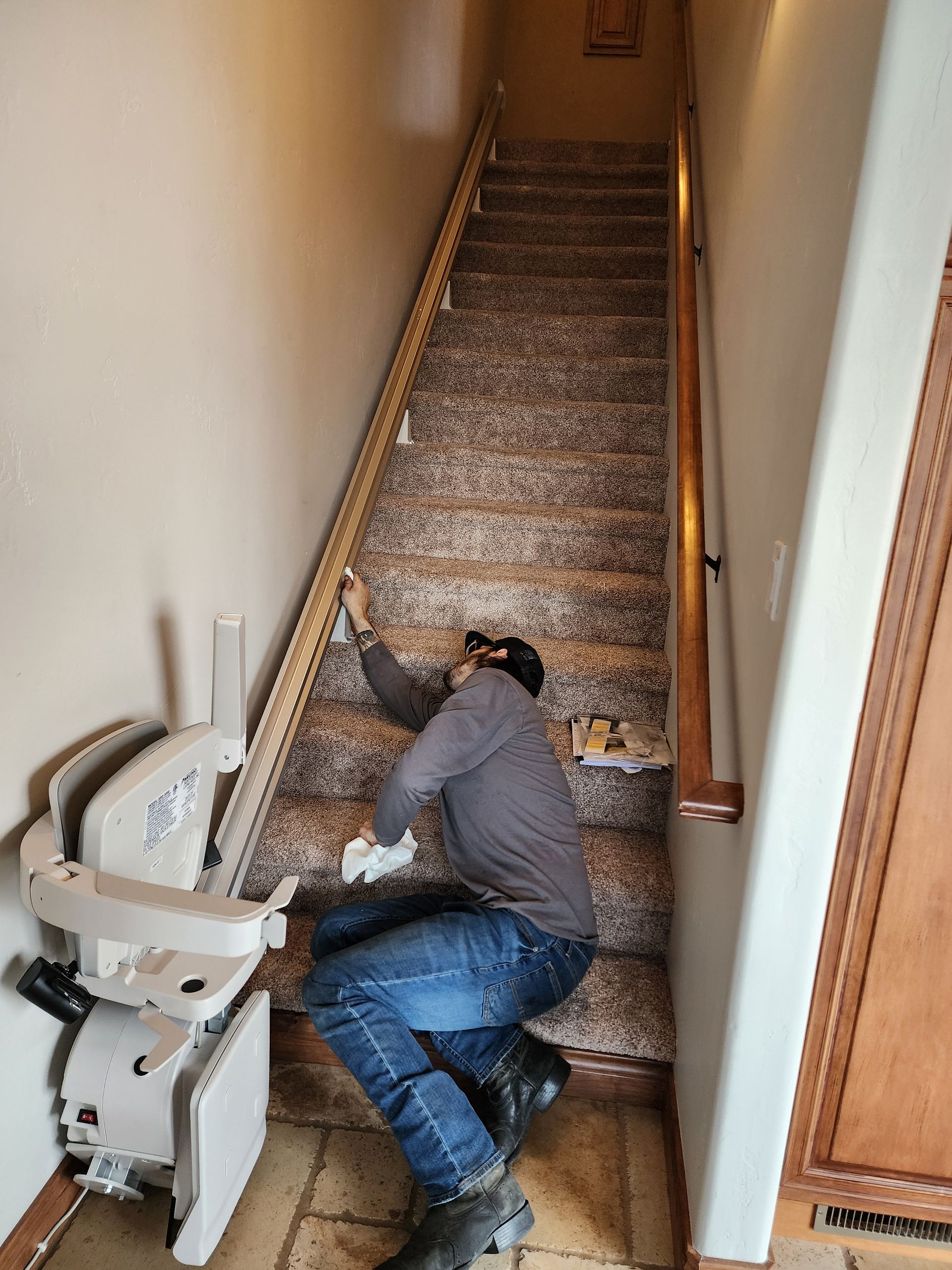 a man is installing a stair lift in a hallway.