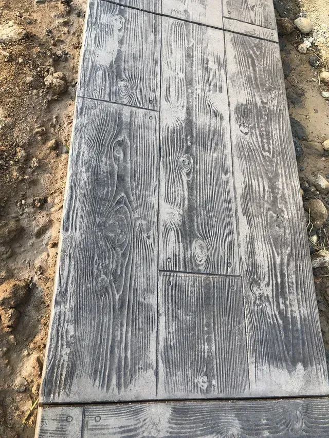 A concrete walkway with a wood grain pattern on it.