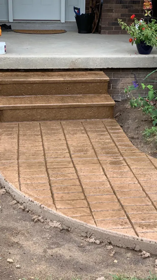 A brick walkway with stairs leading up to a house.
