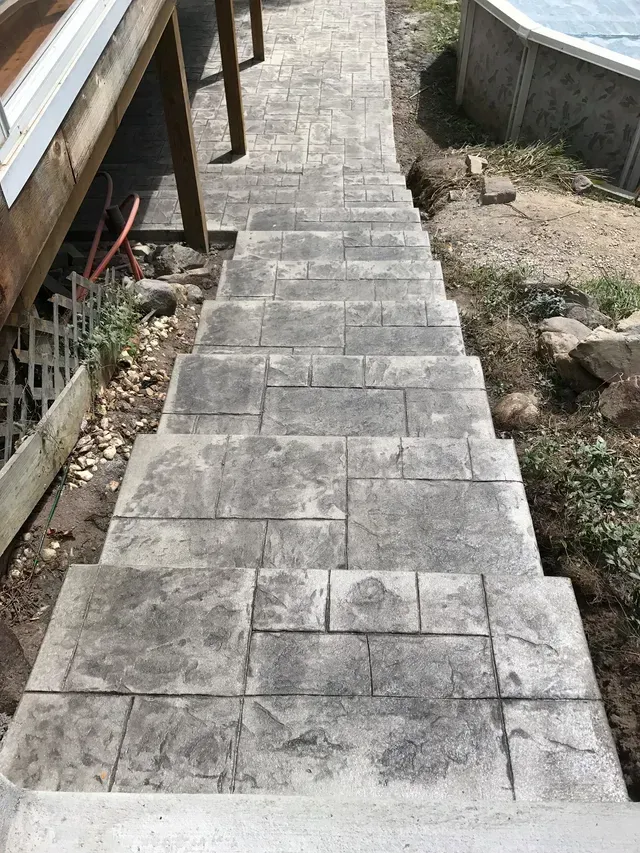 A set of concrete stairs leading up to a pool.