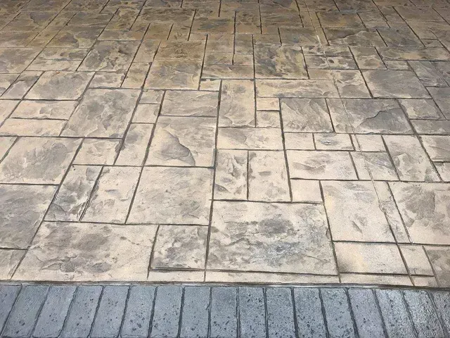 A close up of a concrete floor with a brick border.