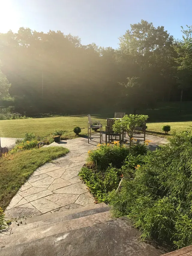 A path leading to a playground in a park with trees in the background.