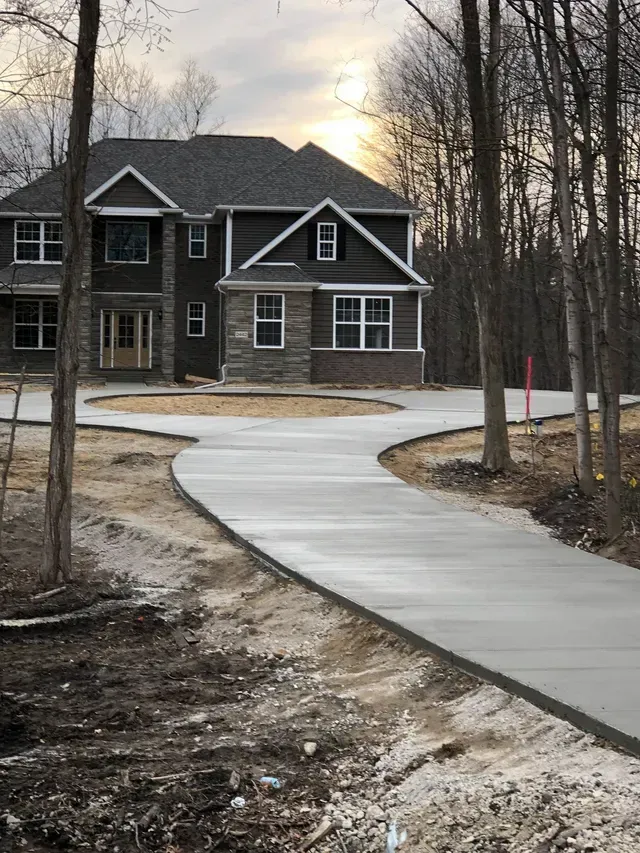 A large house with a concrete driveway leading to it