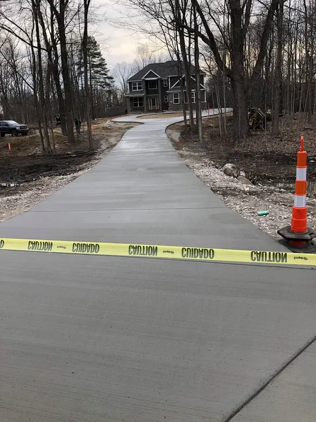 A concrete driveway is being built in front of a house.