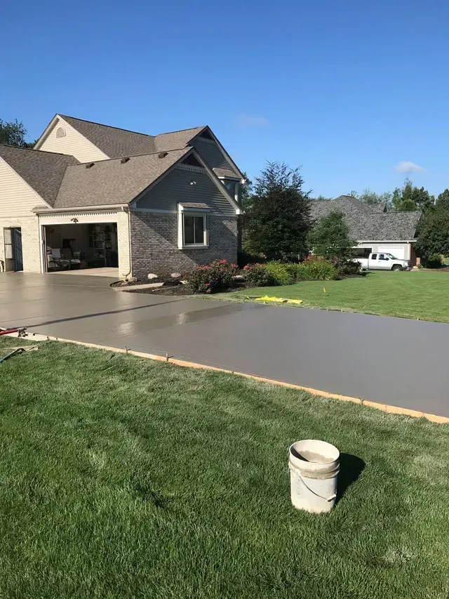 A concrete driveway is being built in front of a house.