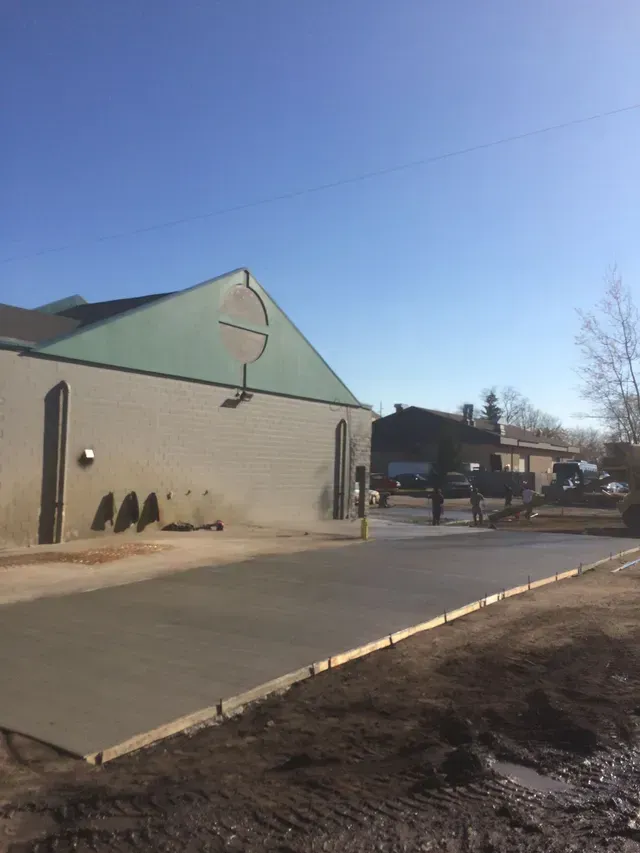 A concrete driveway is being built in front of a building.