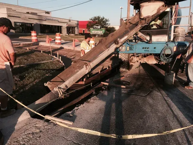 A concrete pump is being used to pour concrete into the ground