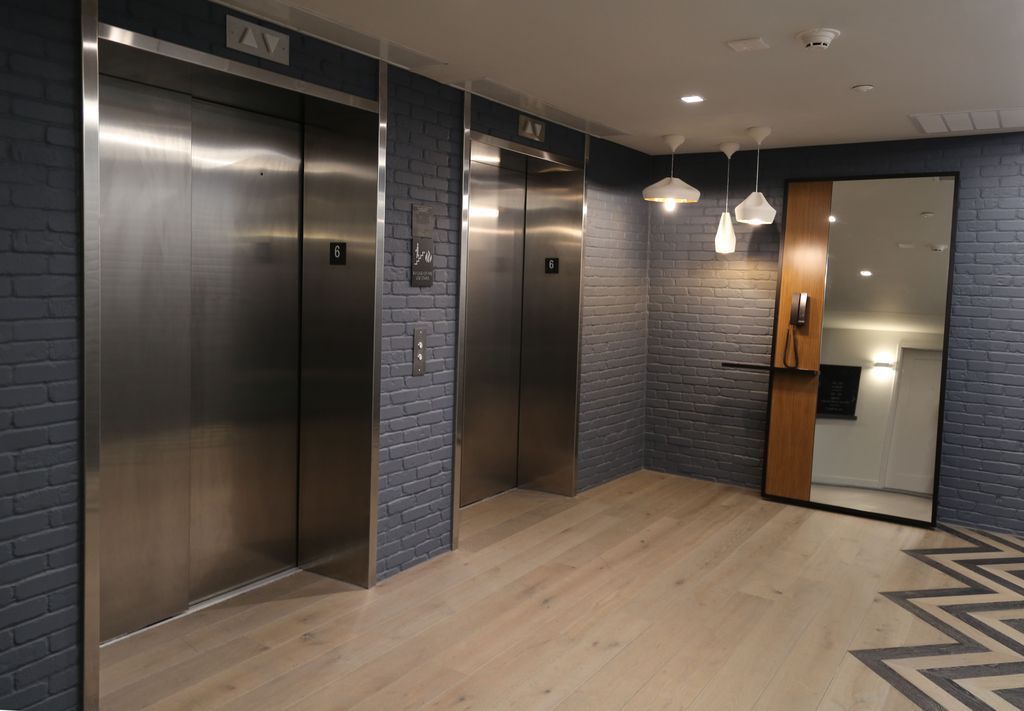 A row of elevators in a building with stainless steel doors