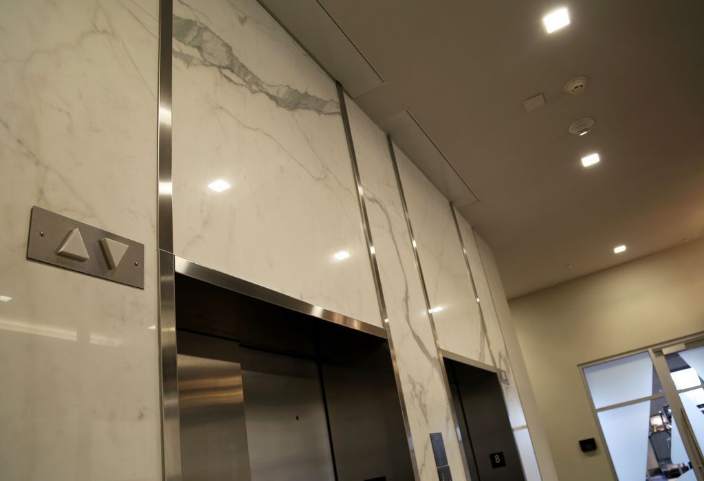 An elevator in a building with marble walls