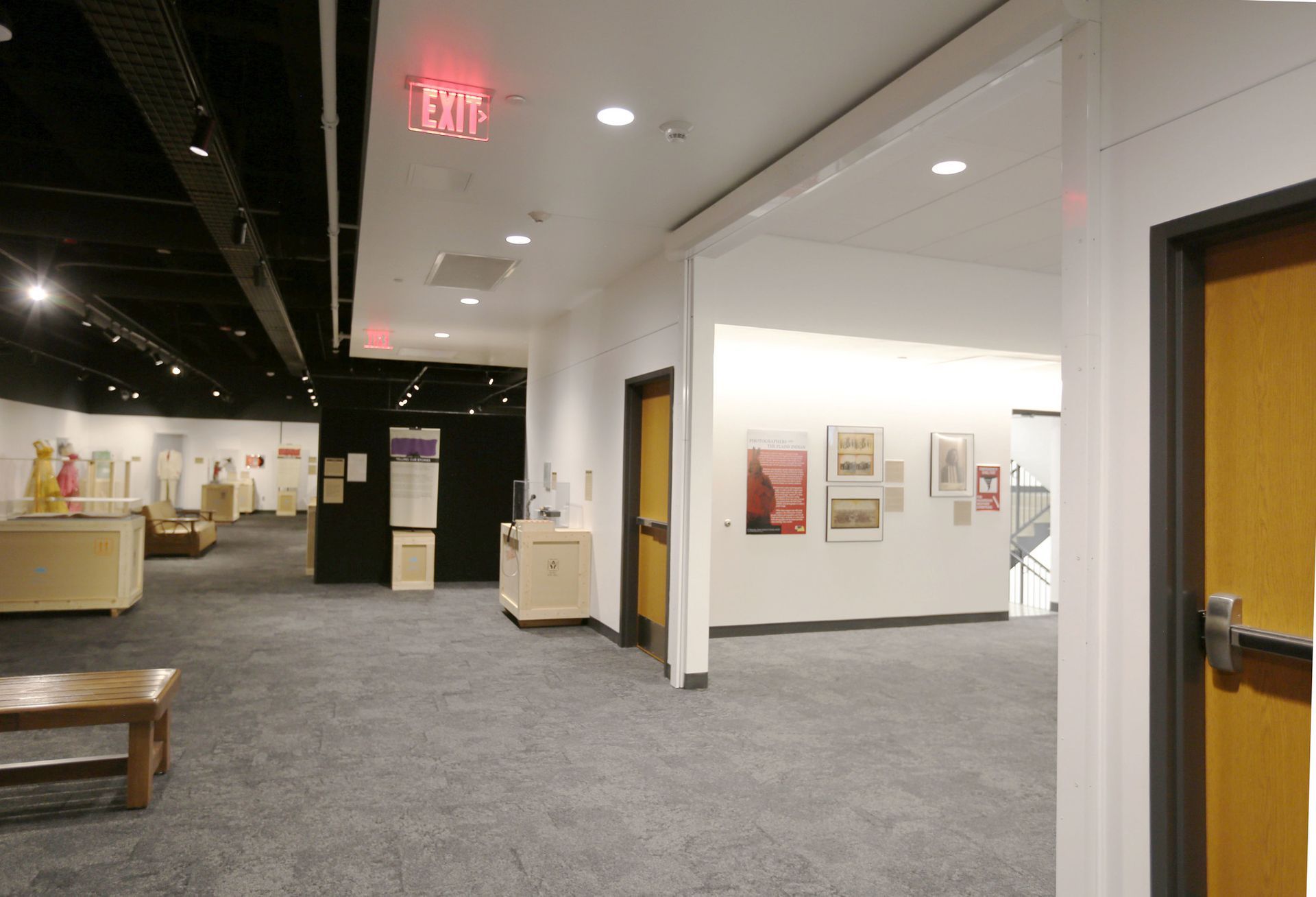 A hallway with a red exit sign on the ceiling