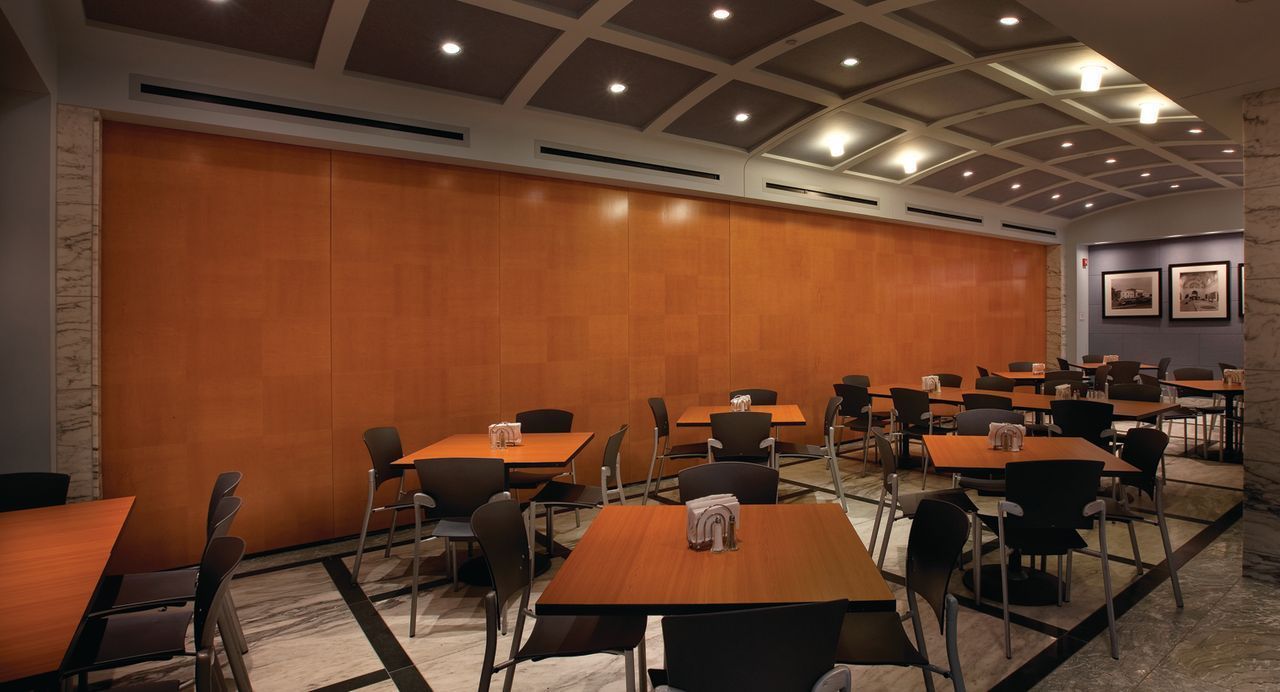 A restaurant with tables and chairs in front of a sliding wall