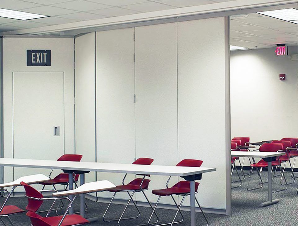 A room with tables and chairs and an exit sign
