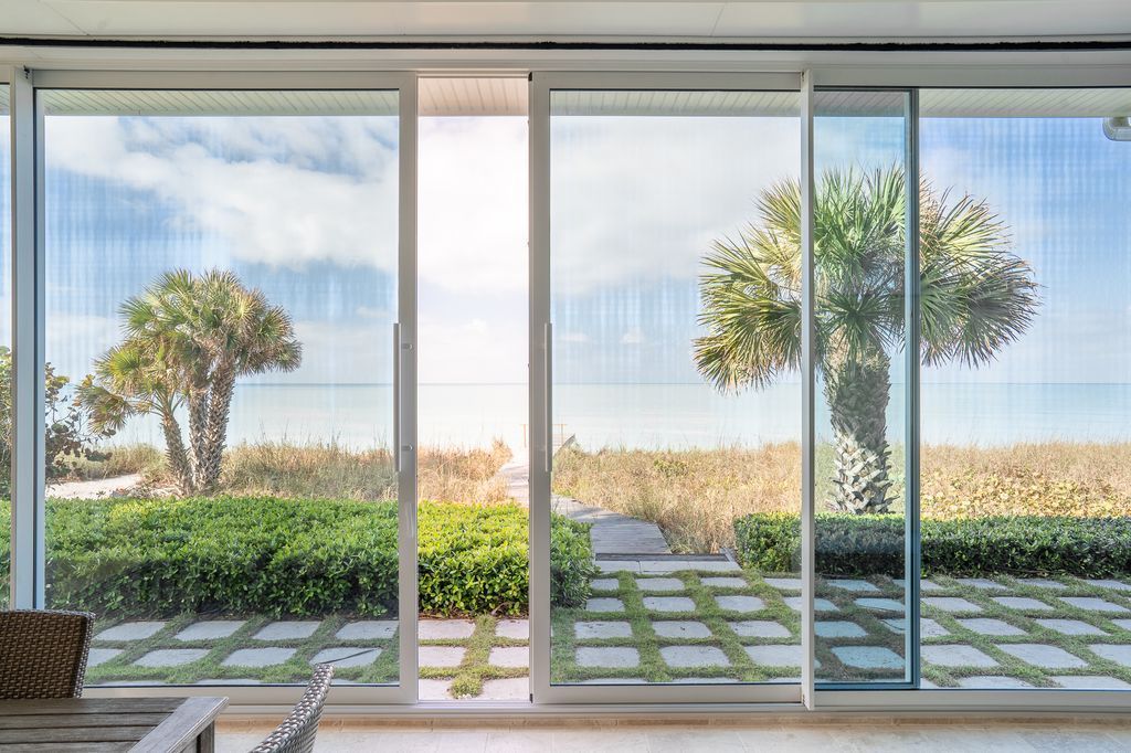 A living room with a view of the ocean through a sliding glass door