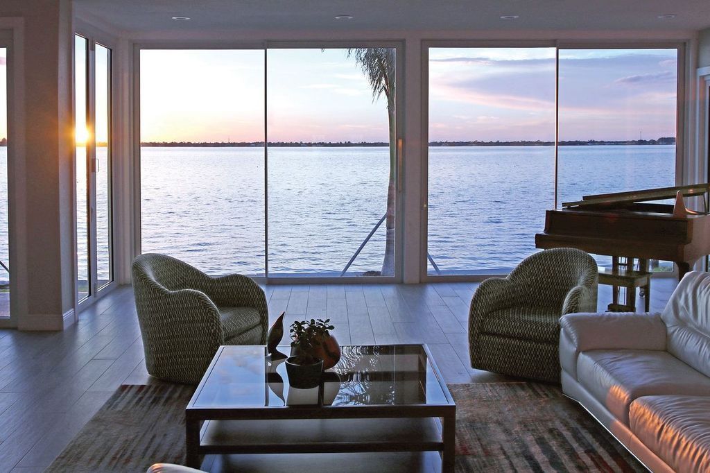 A living room with a view of the ocean and a piano