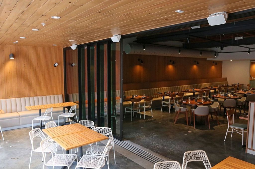 A restaurant with tables and chairs and a sliding glass door
