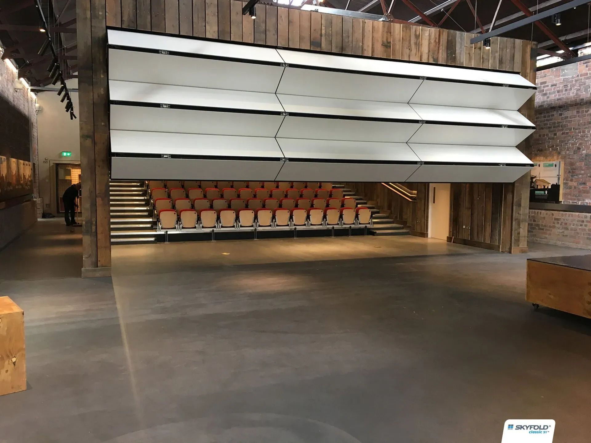 A large empty auditorium with wooden seats and stairs