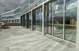 A large building with a lot of windows and a patio in front of it