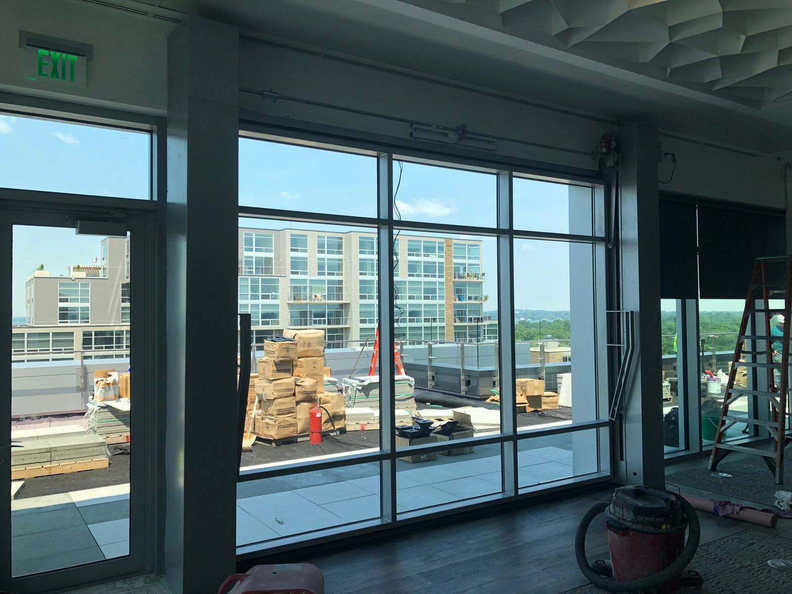 A large room with a lot of windows and an exit sign