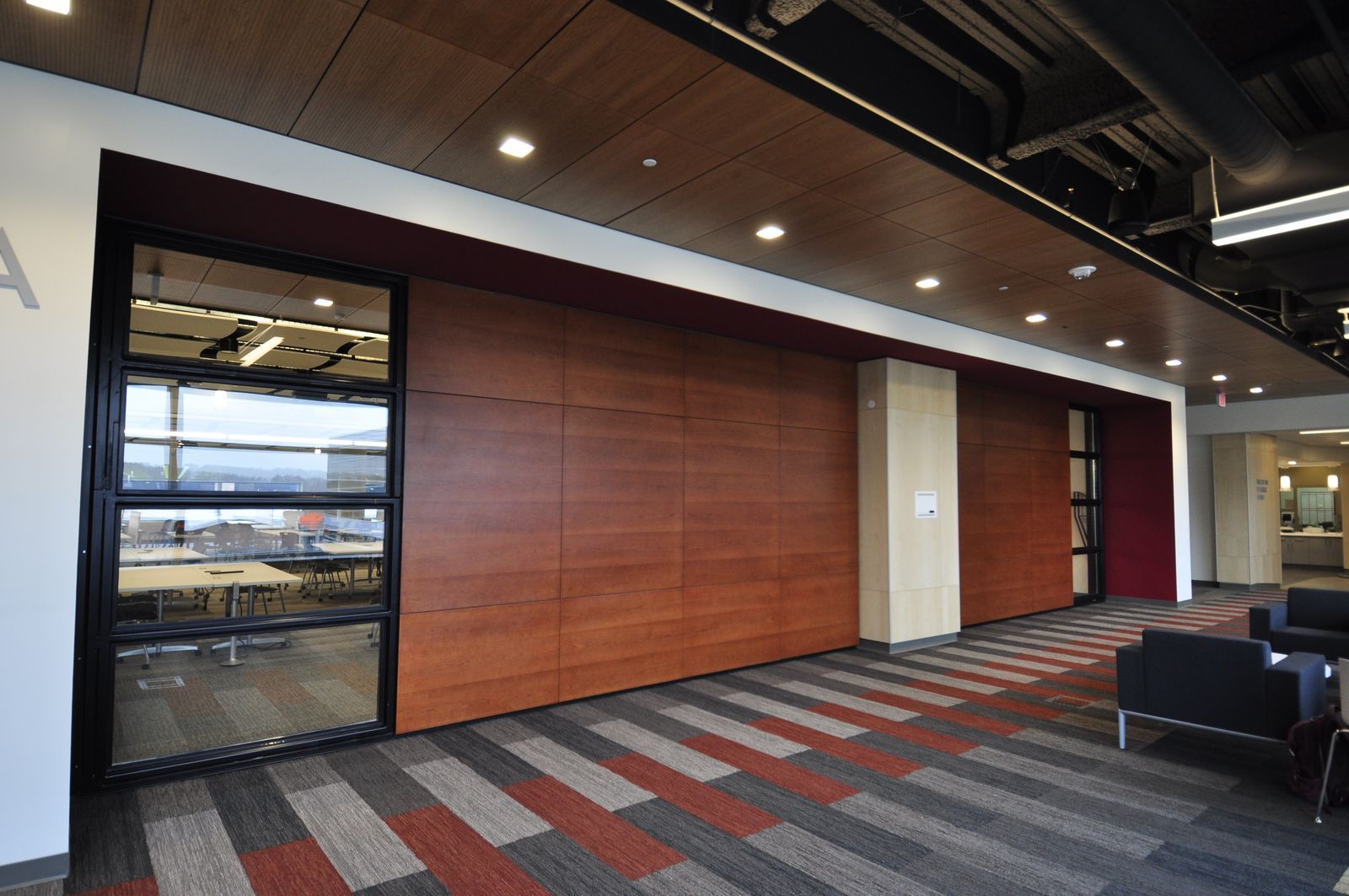 A large room with a wooden wall and a striped carpet