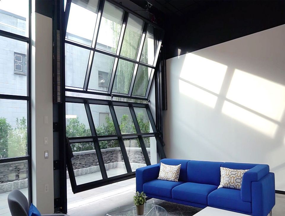 A living room with a blue couch and a large glass door