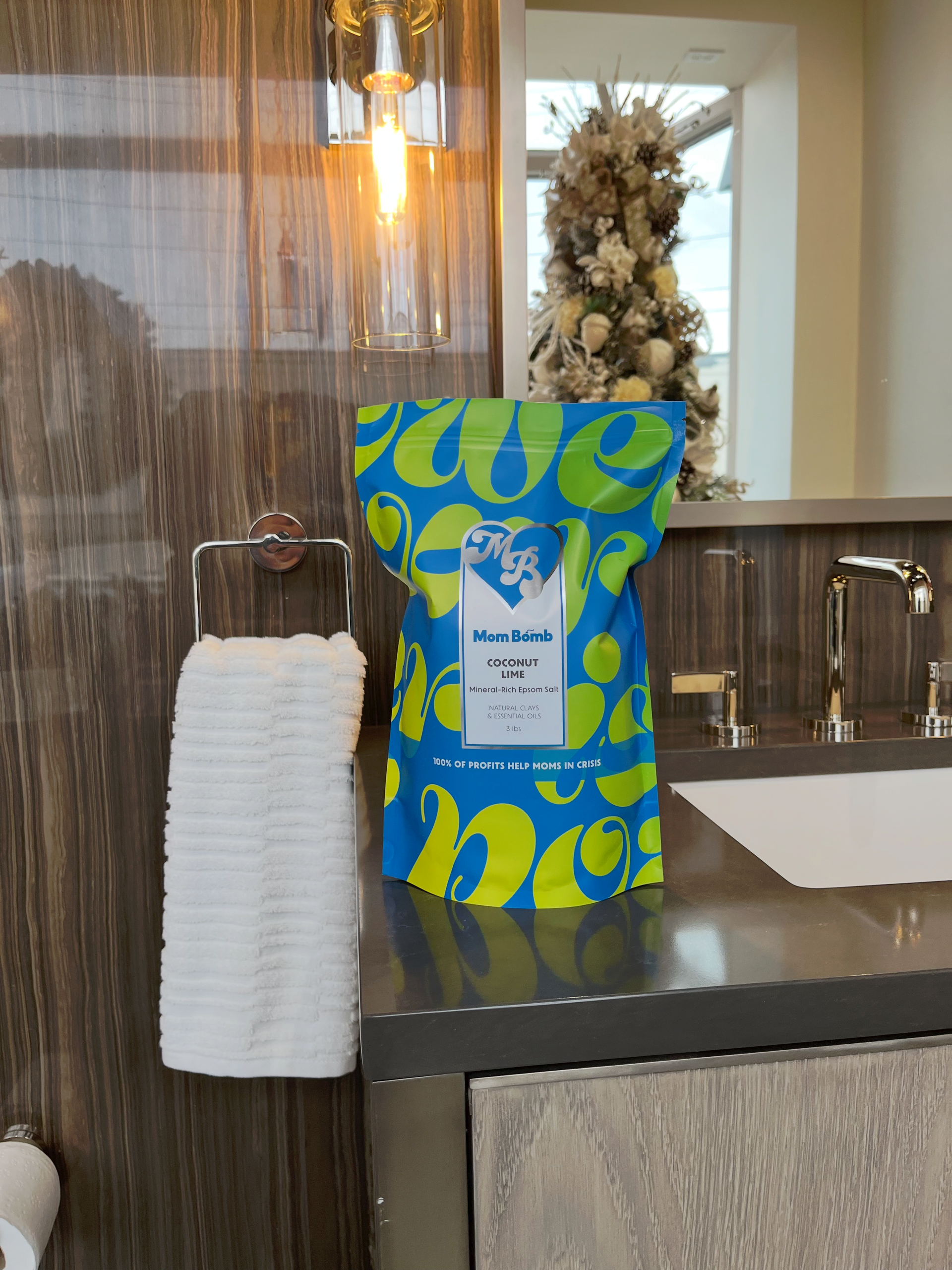 Blue and yellow bag of product on a bathroom countertop, next to a towel.