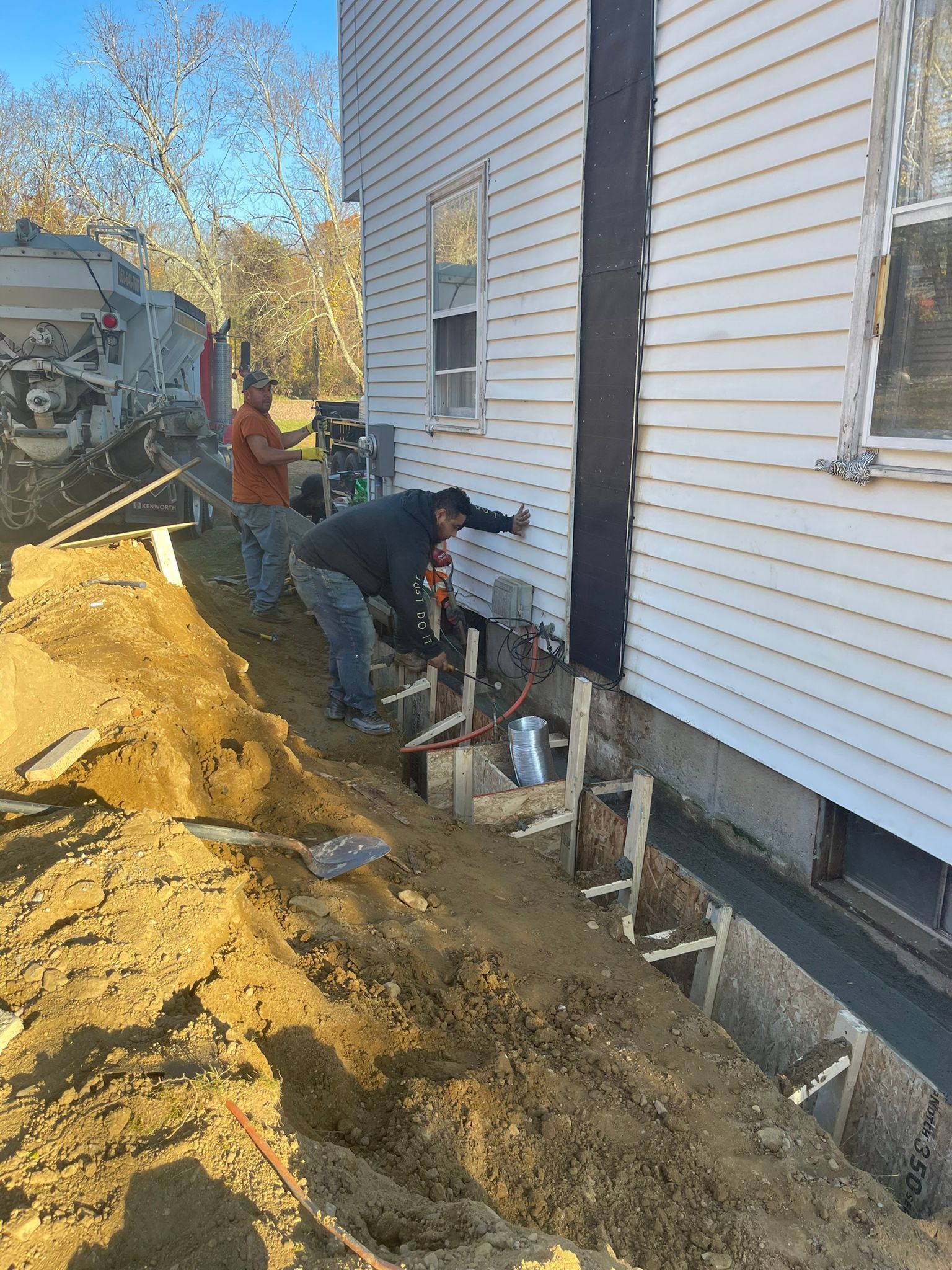 A group of men are working on the side of a house.