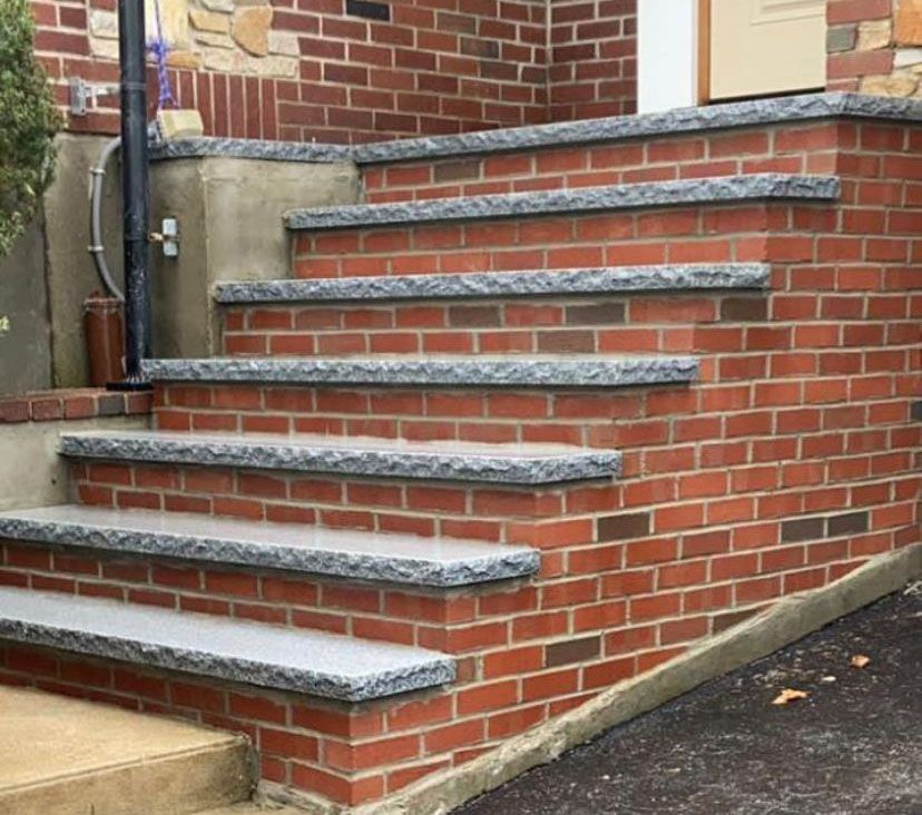 A set of stairs made of bricks and granite.