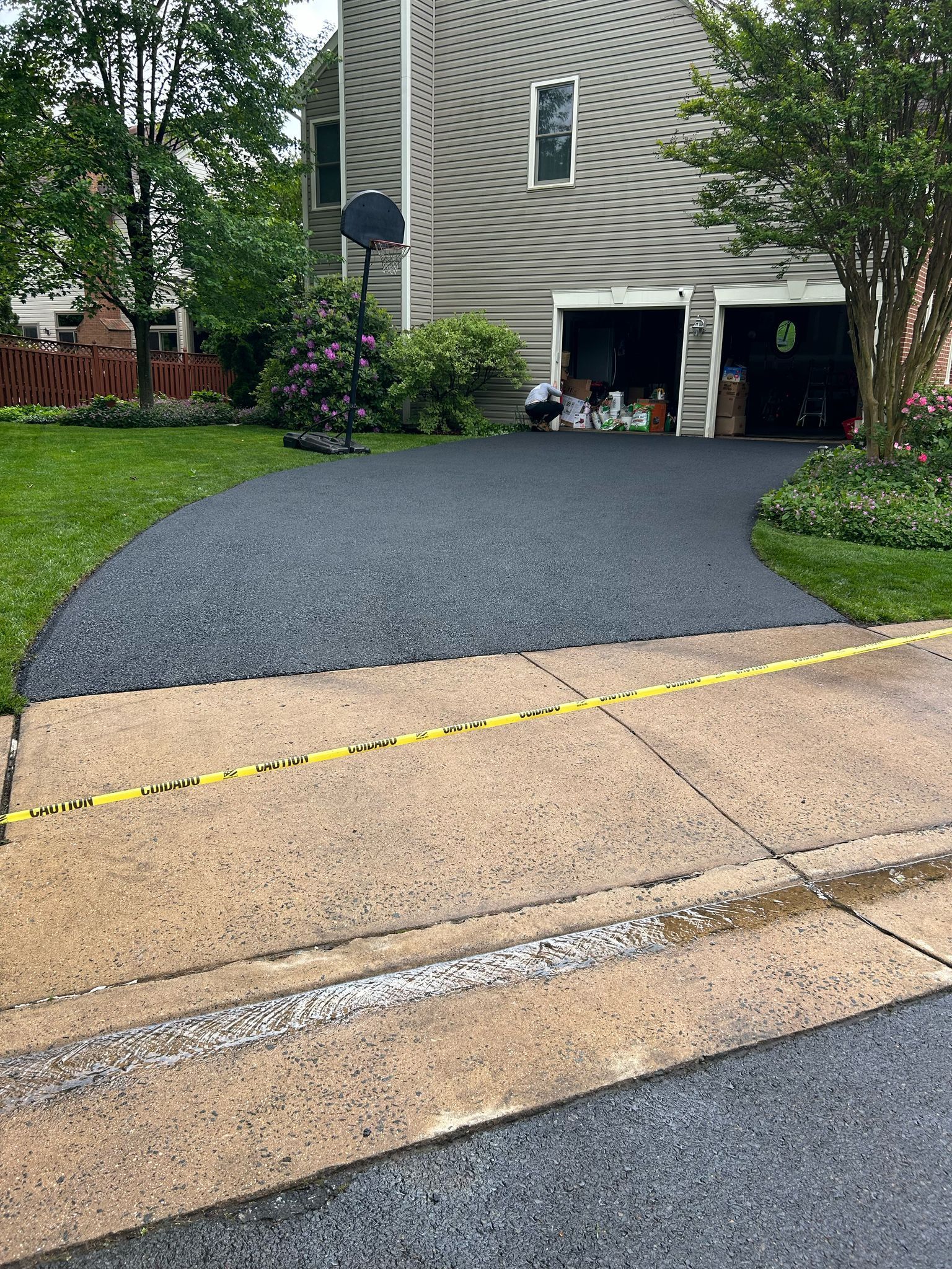 A driveway is being paved in front of a house.