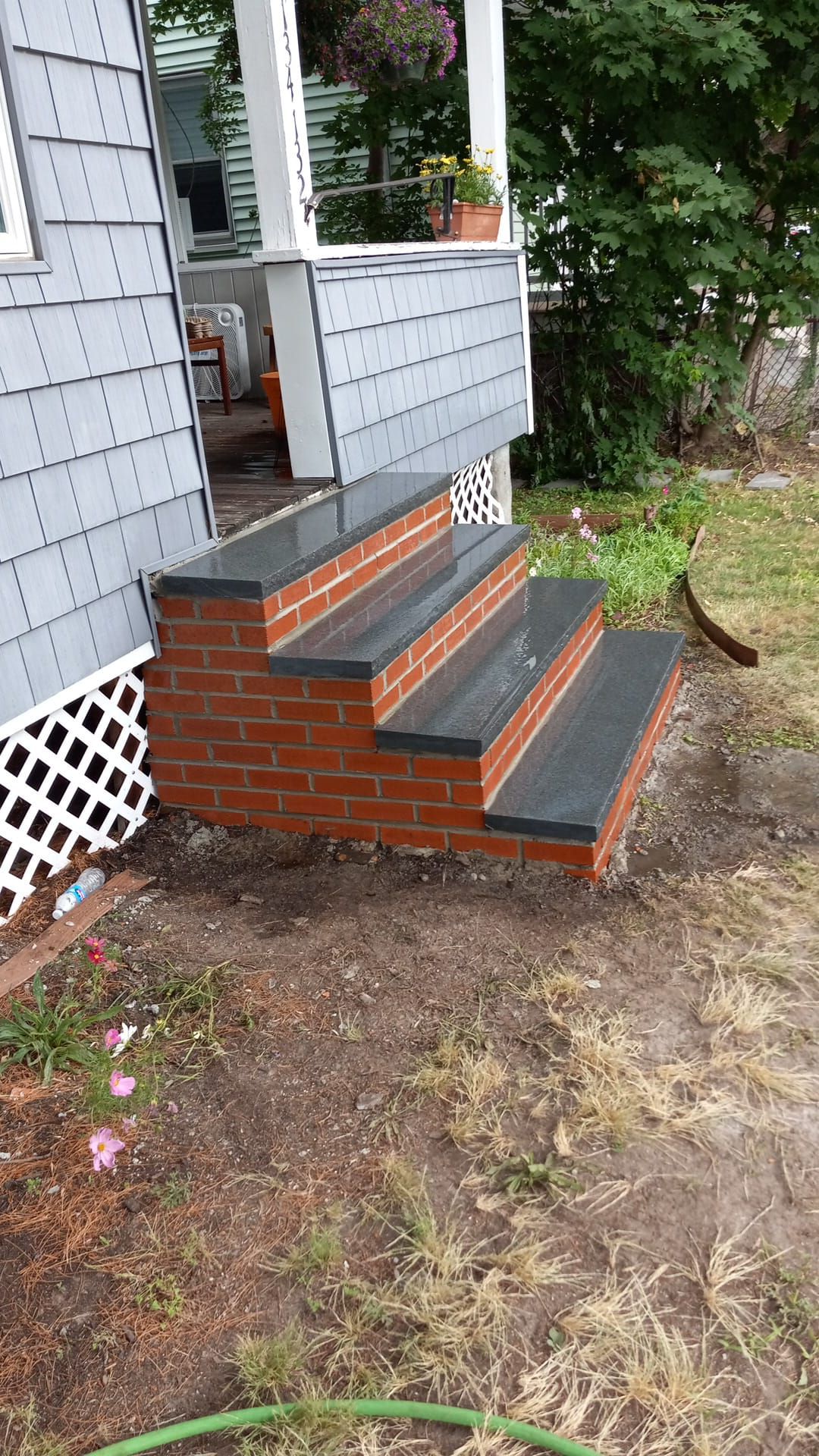 A set of brick steps leading up to a porch of a house.