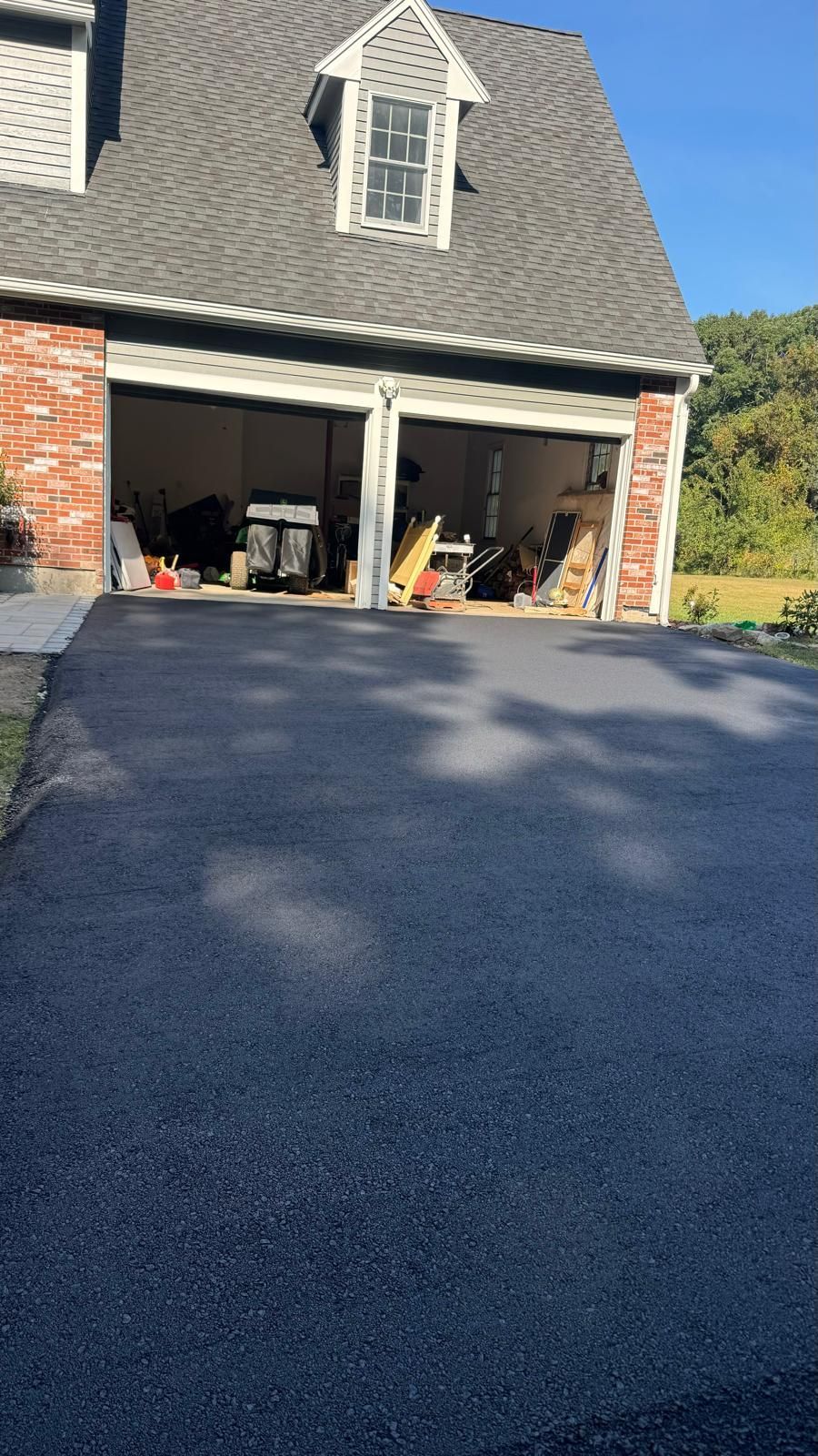 A house with a garage and a driveway in front of it.
