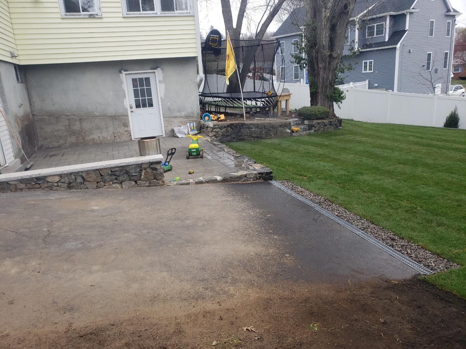A backyard with a lawn and a house in the background.
