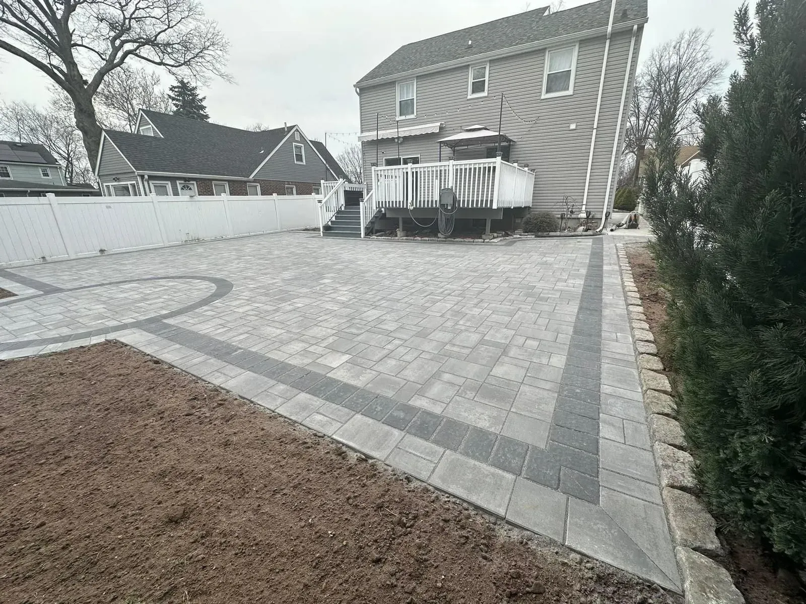 A large house with a brick driveway in front of it.