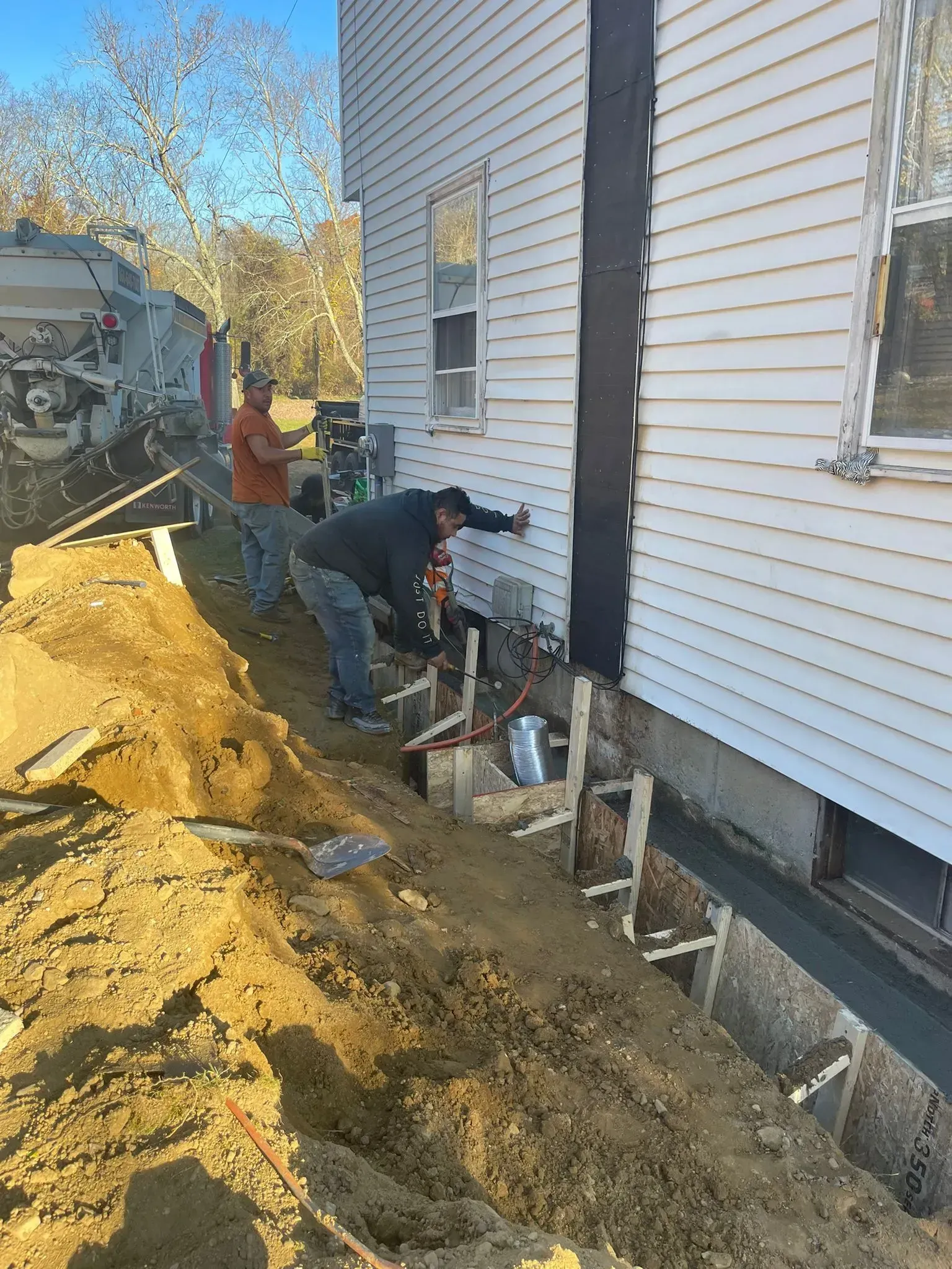 A group of men are working on the side of a house.