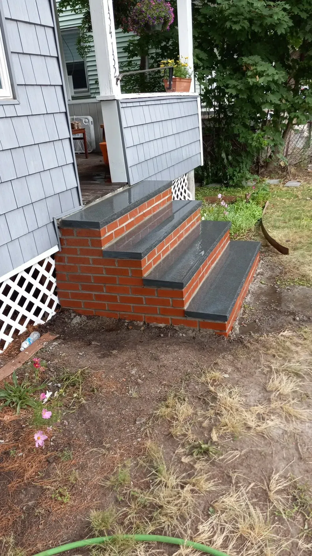 A set of brick steps leading up to a porch of a house.