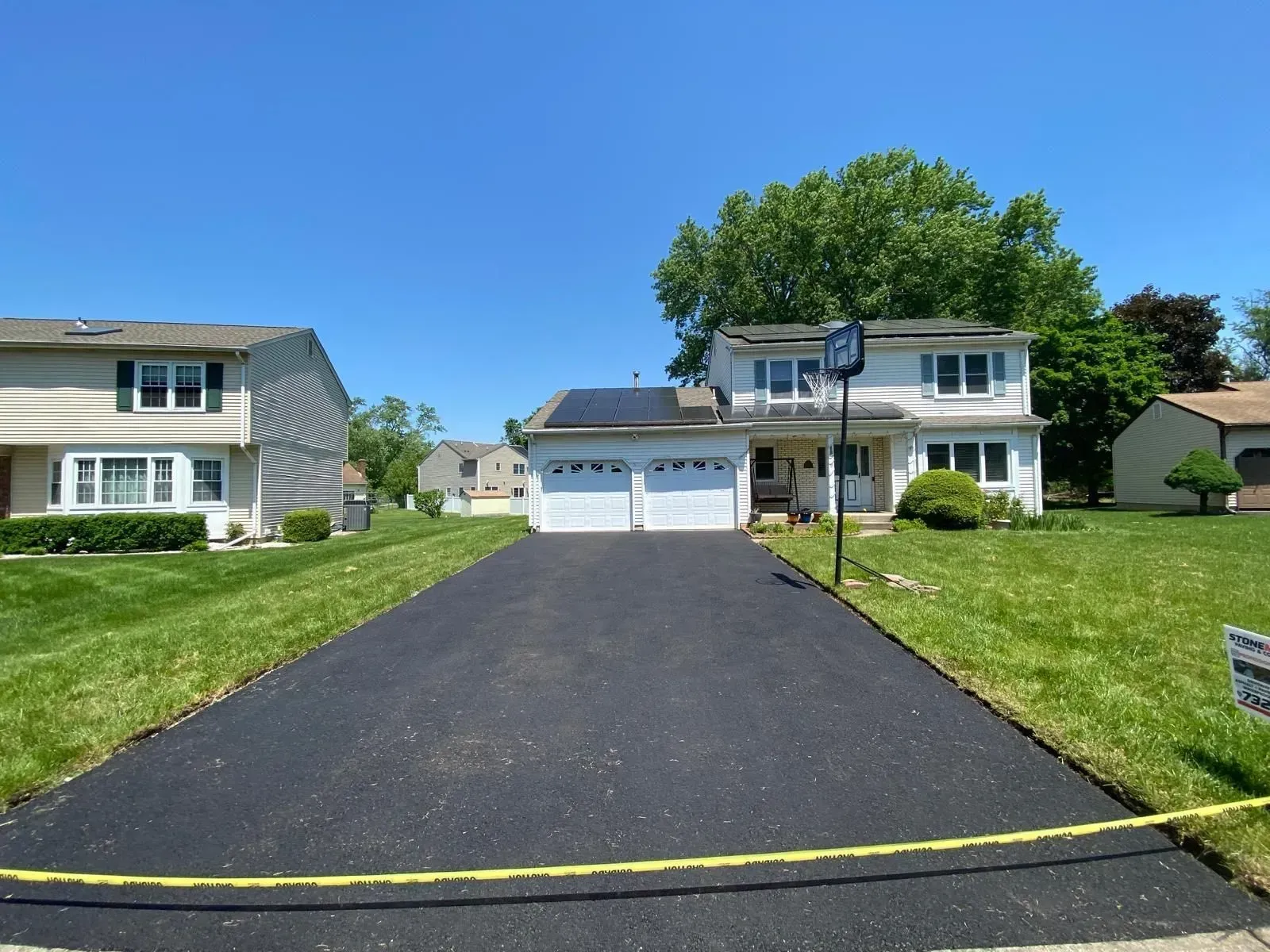 A driveway leading to a house with solar panels on the roof