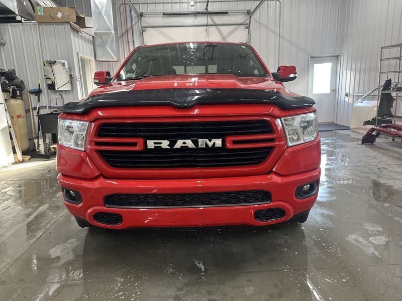 A red ram truck is parked in a garage.