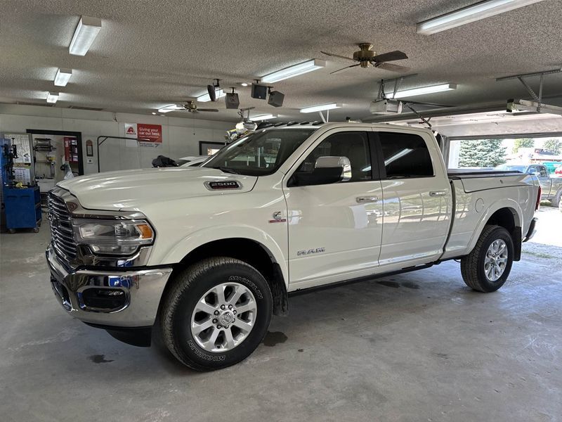 A white dodge ram truck is parked in a garage.