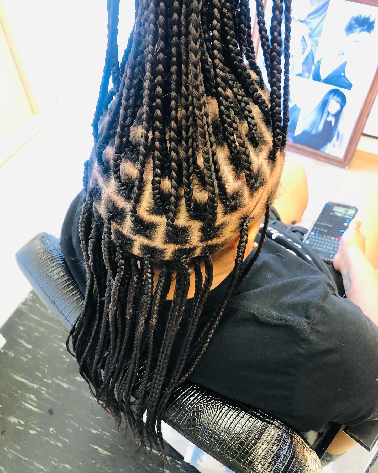 African American man with hair cut into checks and braids hanging down and fixed straight up.